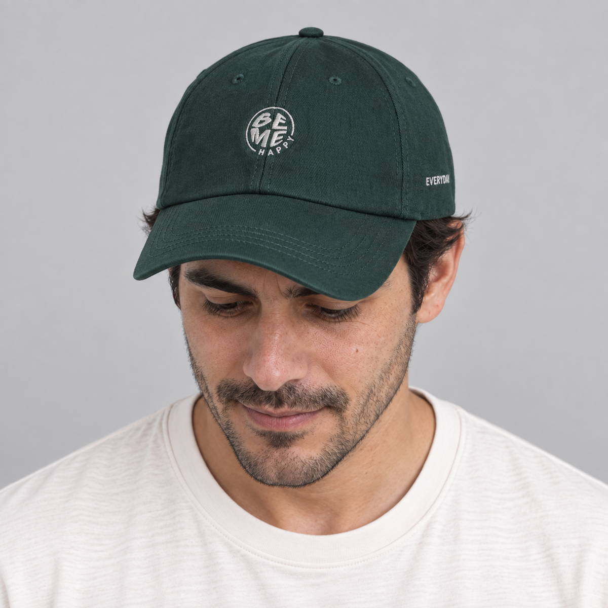 Gorro Be Me Happy verde, hombre mirando hacia abajo mostrando el bordado
